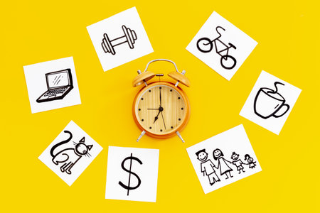 Retro alarm clock and many paper cards with hand drawing of different life activities, top view. Time management concept. Life balance and planning conceptの写真素材