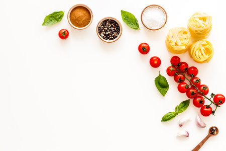 Fettuccine with ingredients for cooking pasta - tomatoes and basil with garlic - on a white background, top view. Flat lay.の写真素材