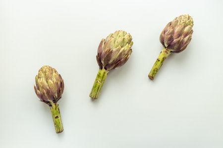 Whole heads of purple artichokes top view. Vegetables food ready to cook.の写真素材