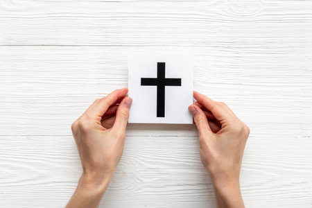 Hands holding Christianity cross symbol. World religious concept.の写真素材