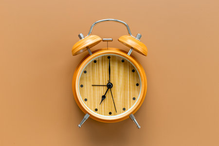 Vintage wooden alarm clock with bells at seven o'clock. Morning routine. In time concept.の写真素材
