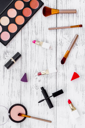 Pattern of various makeup tools and cosmetics products. Blusher, mascara, lipstick, nail polish and brushes, top view.の写真素材