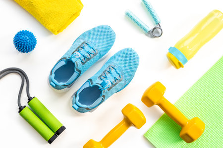 Gym sports equipment with sneakers and dumbbells, top view. Fitness concept.の写真素材