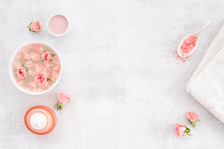 Roses essence water in bowl with petals and skin care cosmetic products with flowers essential oil.の写真素材