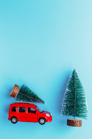 Red toy car with Christmas tree on the roof. Festive New Year decoration and Christmas background.の写真素材