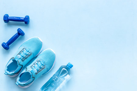 Gym sports equipment with sneakers and dumbbells, top view. Fitness concept.の写真素材