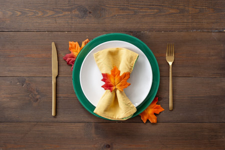 Festive Thanksgiving table setting with autumn leaves and plate, cutlery and napkin decorated, flat lay. Top view.の写真素材