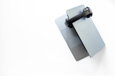 Top view of white business office desk with laptop and headphones. Online conference. Call center work space.の写真素材