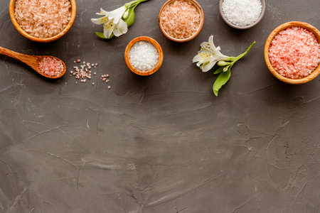 Spa treatment body care cosmetics - sea salt and scrubs in bowls, top view.