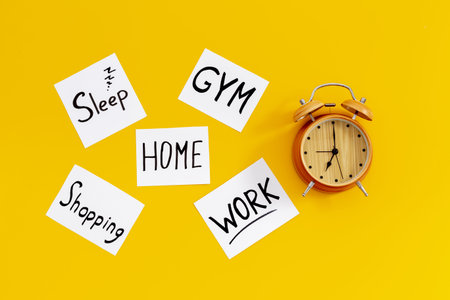 Retro alarm clock and many paper cards with hand drawing of different life activities, top view. Time management concept. Life balance and planning conceptの写真素材