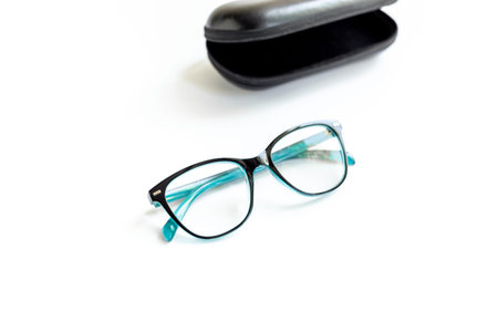 Stylish eyeglasses with glasses case on white. Eye care and protection concept.
