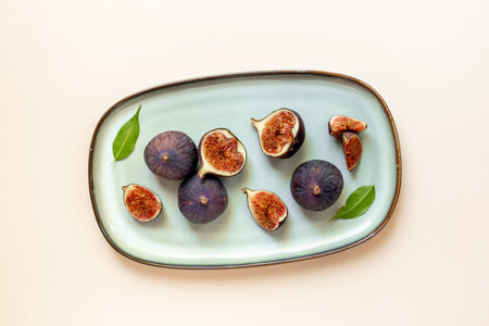 Fresh ripe figs on a plate top view on a stone background.