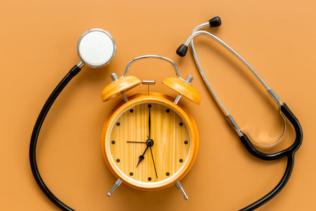 Stethoscope and vintage alarm clock, top view. Time for medical checkup.