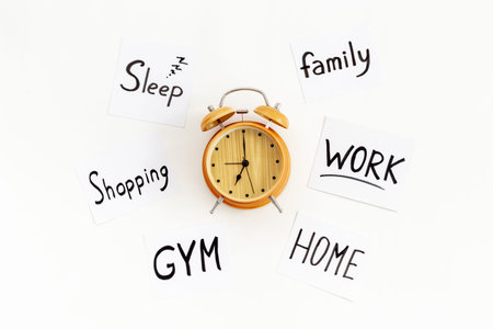 Retro alarm clock and many paper cards with hand drawing of different life activities, top view. Time management concept. Life balance and planning conceptの写真素材