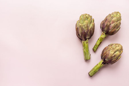 Whole heads of purple artichokes top view. Vegetables ready to cook.の写真素材