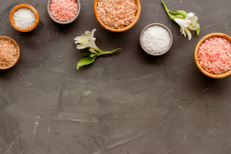 Beauty spa therapy cosmetics and wellness flat lay - sea salt in many bowls with flowers, top view.の写真素材