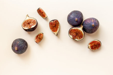 Purple ripe figs and slices top view on a stone background.