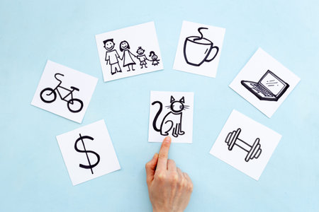 Hand is choosing Cat card from many paper cards with hand drawing of different life activities. Life balance concept.の写真素材