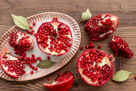 Plate full of fresh ripe pomegranate with cut in half and pieces, top viewの写真素材