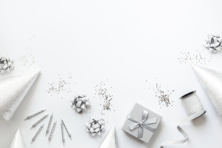 Silver party decoration - streamers with confetti and cones on white background, top view.の写真素材