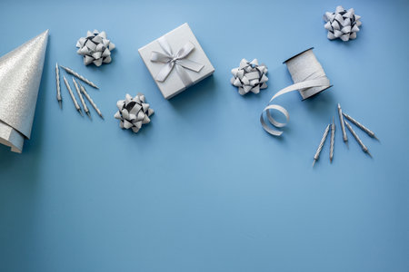 Party silver streamers with confetti and cones on blue background, top view.の写真素材