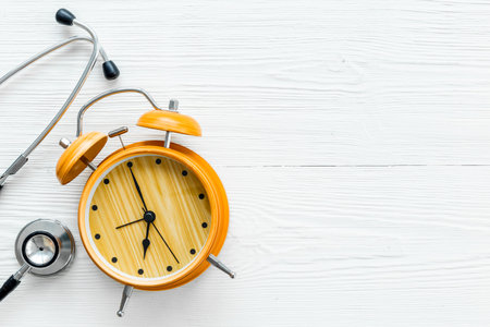 Stethoscope and vintage alarm clock, top view. Time for medical checkup.の写真素材