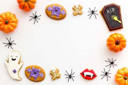Halloween cookies in a shape of ghosts and bats with pumpkins, top view.の写真素材