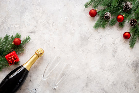 Christmas decoration top view - fir tree branch with champagne bottle and two glasses. Festive flat table setting.の写真素材