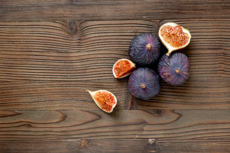 Purple ripe figs and slices top view on a wooden background.の写真素材
