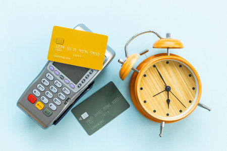 Pos payment terminal with bank card and alarm clock. Transaction speed. Time to pay concept.