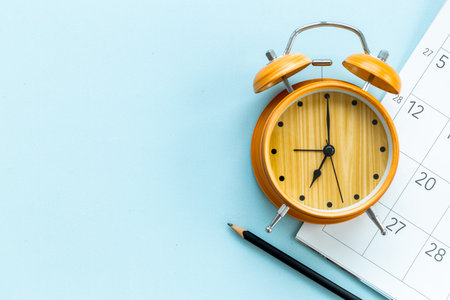 Alarm clock is on calendar with pencil, top view. Planning and time management concept.の写真素材