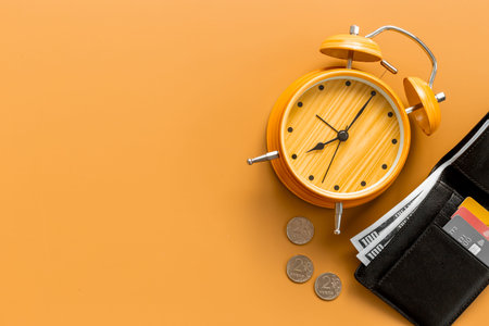 Black wallet with money cash bank card and alarm clock. Time to pay taxes or credit concept.