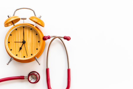 Stethoscope and vintage alarm clock, top view. Time for medical checkup.の写真素材