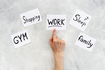 Hand is choosing Work card from many paper cards with hand drawing of different life activities. Life balance concept.の写真素材