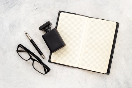 Male accessories flat lay with perfume notepad and glasses in black colorの写真素材