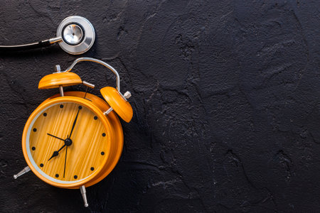 Stethoscope and vintage alarm clock, top view. Time for medical checkupの写真素材