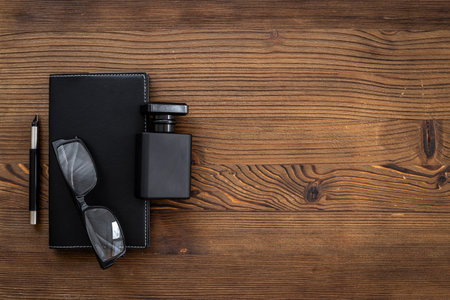 Male accessories flat lay with perfume notepad and glasses in black colorの写真素材