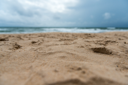 sand on beach closeup and sun in blue sky. soft focus on bottom of pictureの写真素材