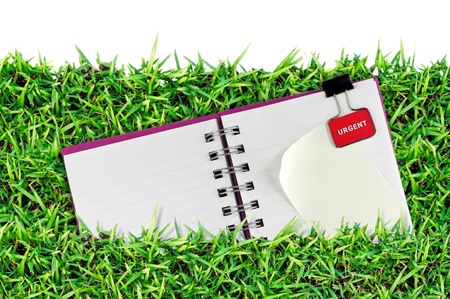 blank page of note book on grass and white isolateの写真素材