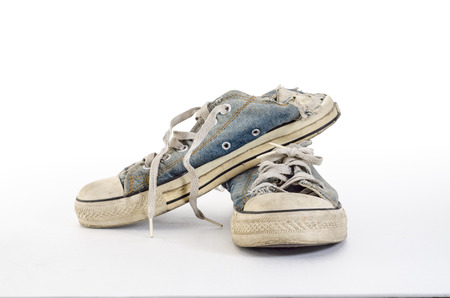 A pair of old direty sneakers on a white backgroundの写真素材