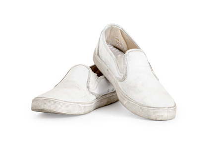 A pair of old dirty sneakers on a white backgroundの写真素材