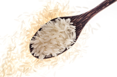 Rice grain in wooden spoon on white background     Selective Focusの写真素材