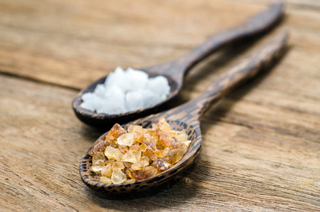 two wood spoon with sal  and crystalline sugar on wood tableの写真素材