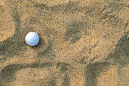 A golf ball on the sand ; top viewの写真素材
