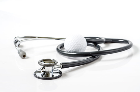 stethoscope and golf ball on white backgroundの写真素材