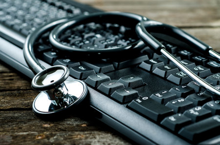Stethoscope on a Computer Keyboard on wooden