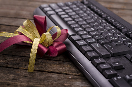 red ribbon on top of wooden near black Keyboard - very shallow depth of field
の写真素材