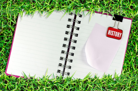 blank page of note book on grass and Binder Clipの写真素材