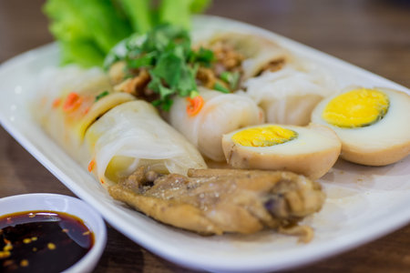 Portion of spring rolls on old wood with spicy sauce, vegetables and in noodle tubeの写真素材