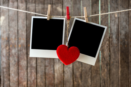 Two blank instant photos hanging on the clothesline with  red heartの写真素材